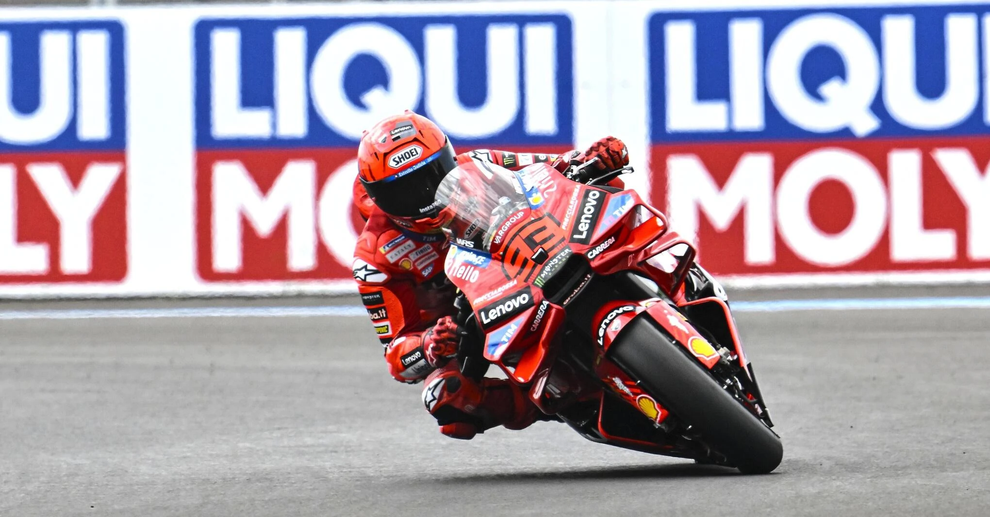 MotoGP 2025 Balaton Park Circuiten Marc Márquez uralja a pályát. Éles jobbos kanyarban kanyarodik mögötte Fabio Di Giannantonió és Franco Morbidelli