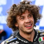 Marco Bezzecchi közelről mosolyog a verseny után, az Aprilia Racing MotoGP-pilótája a paddockban.