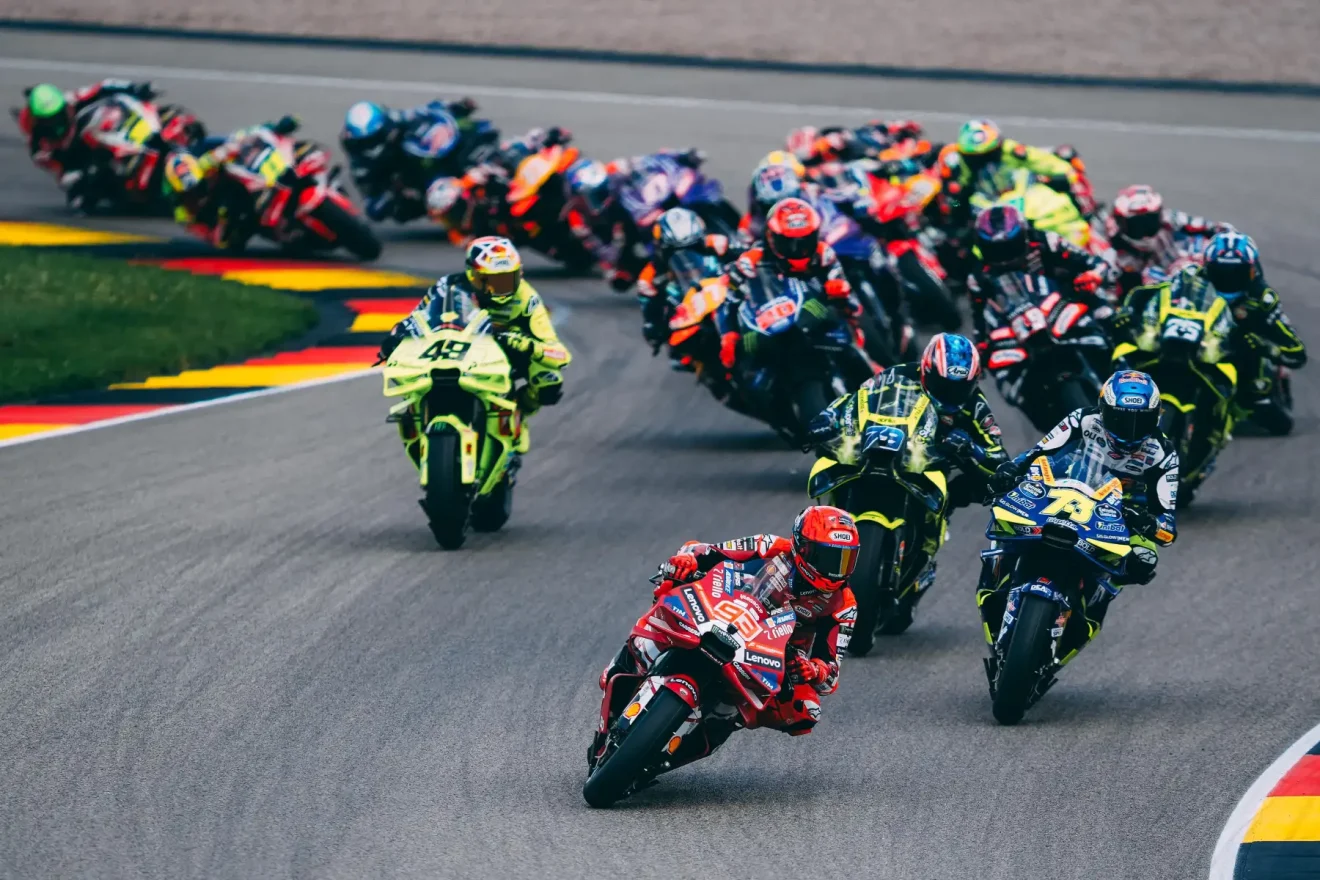 MotoGP közvetítés: DAZN kapta meg újra a MotoGP közvetítési jogot. A képen egy MotoGP közvetítés látható ahogy egy szűk kanyarban megy a MotoGP mezőny Marc Marquez az élen.