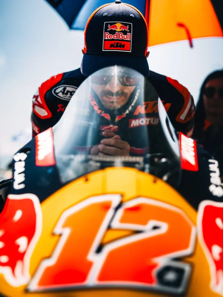 Maverick Viñales a Tech3 csapat színeiben egy MotoGP motoron ülve a boxutcában.