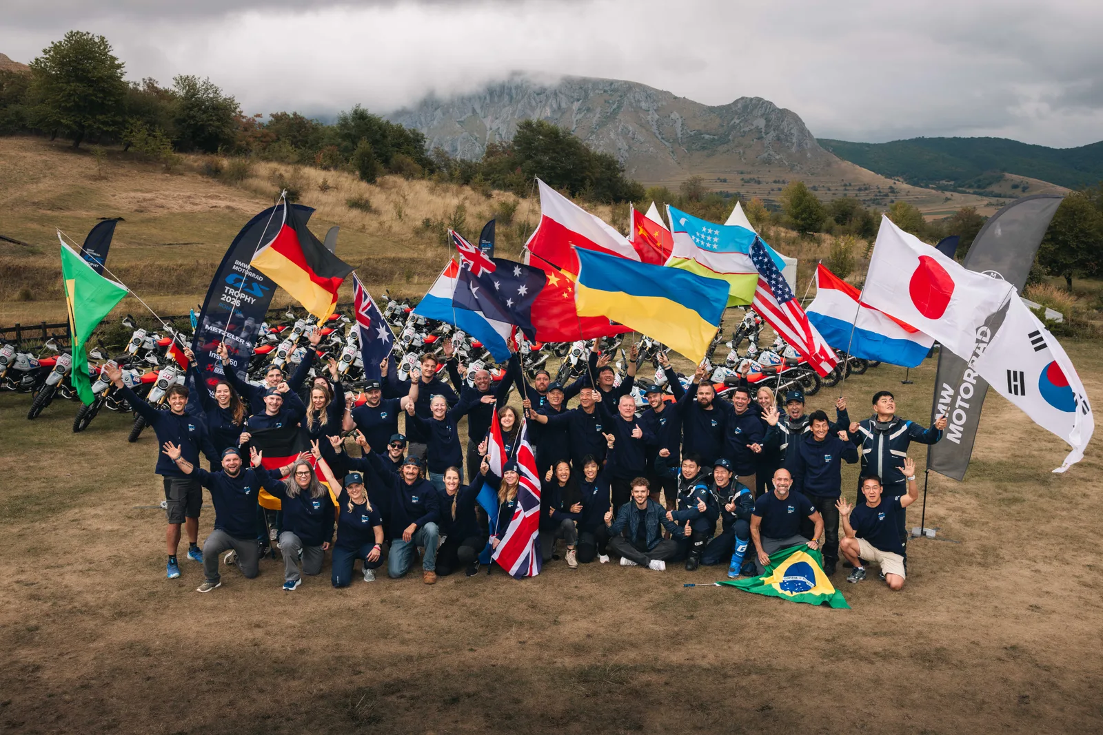 A BMW Motorrad International GS Trophy 2026 résztvevői Romániában, nemzeti zászlókkal és BMW R 12 G/S motorokkal