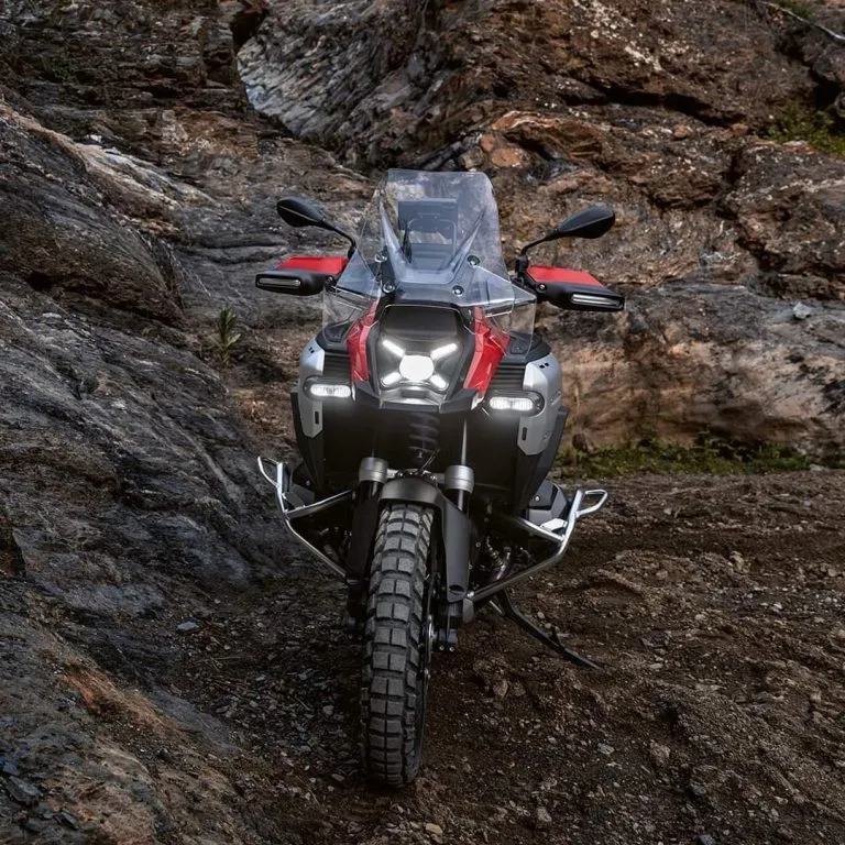 Piros színű BMW R1300GS szemből aminek világít a lámpája